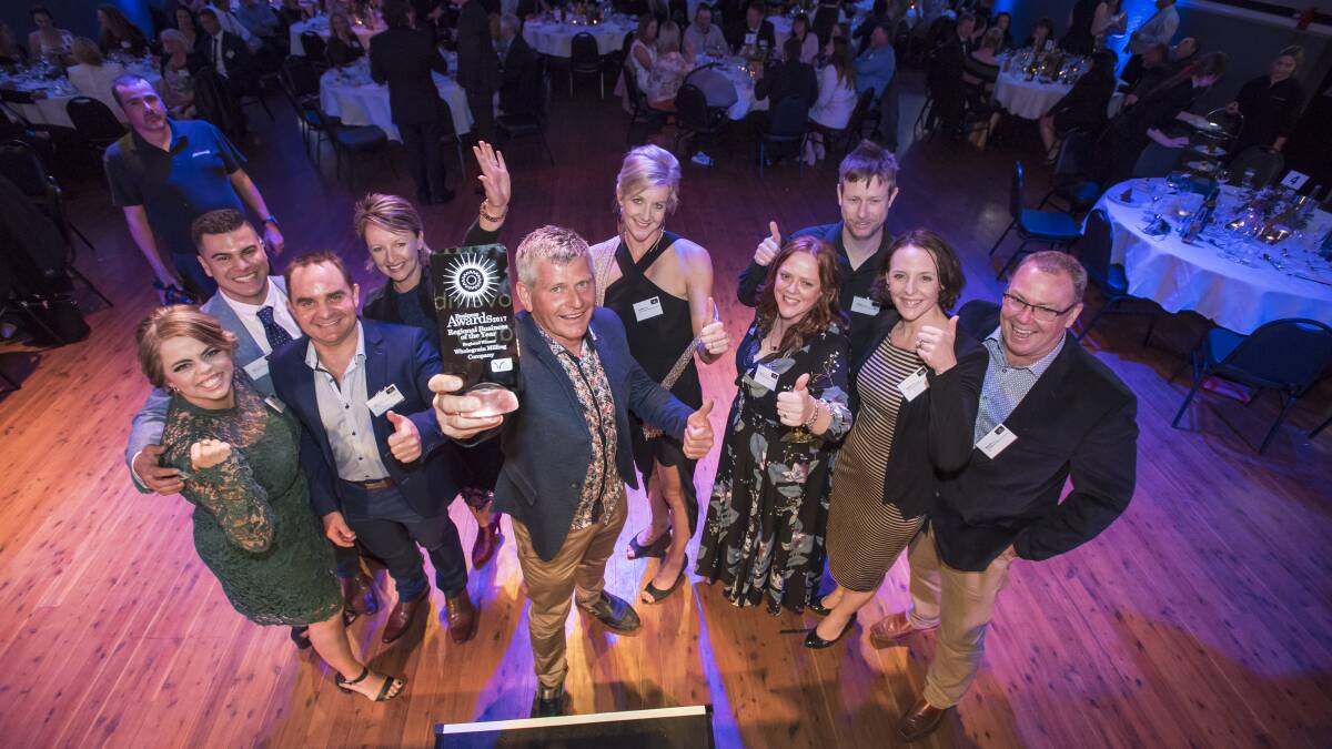 Grinners: Wholegrain Milling Company owner Craig Neale (centre with trophy) celebrates the win at the Regional Business Awards on Friday night. Photo: Peter Hardin.