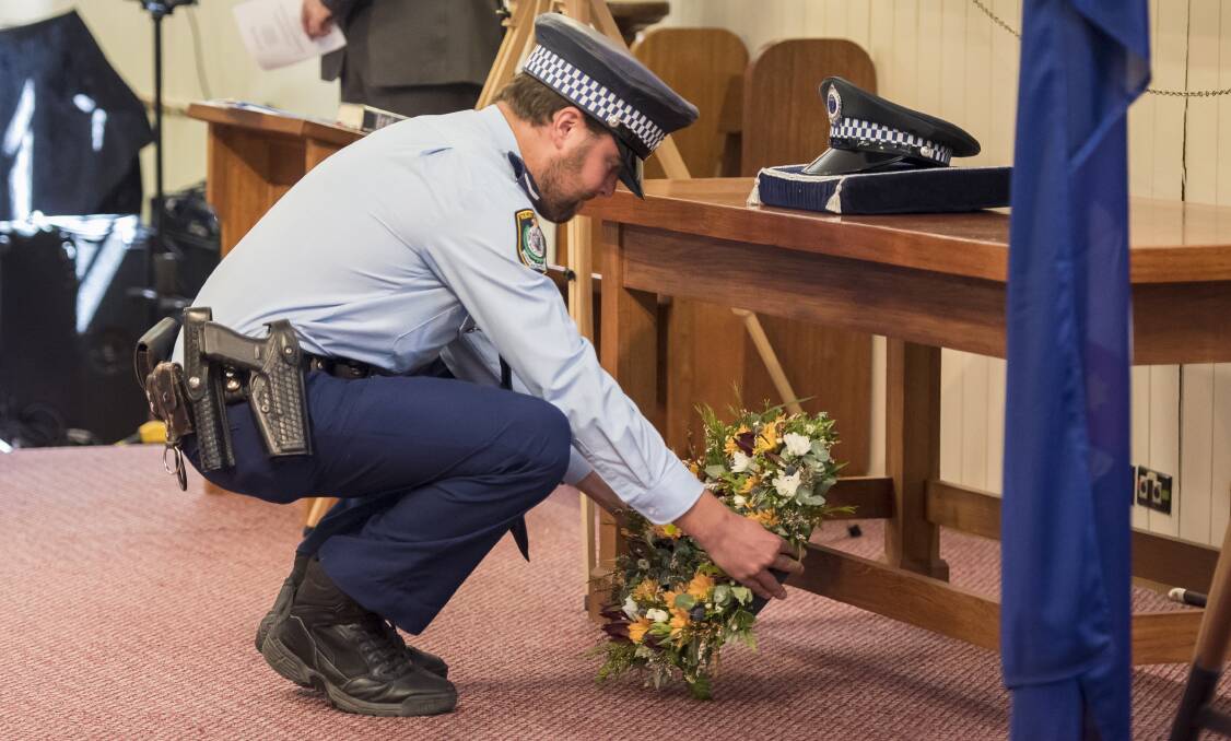 Remembering the fallen: Oxley Constable Joshua Naughtin lays a wreath to commemorate the service of the officers that have passed. Photo: Peter Hardin