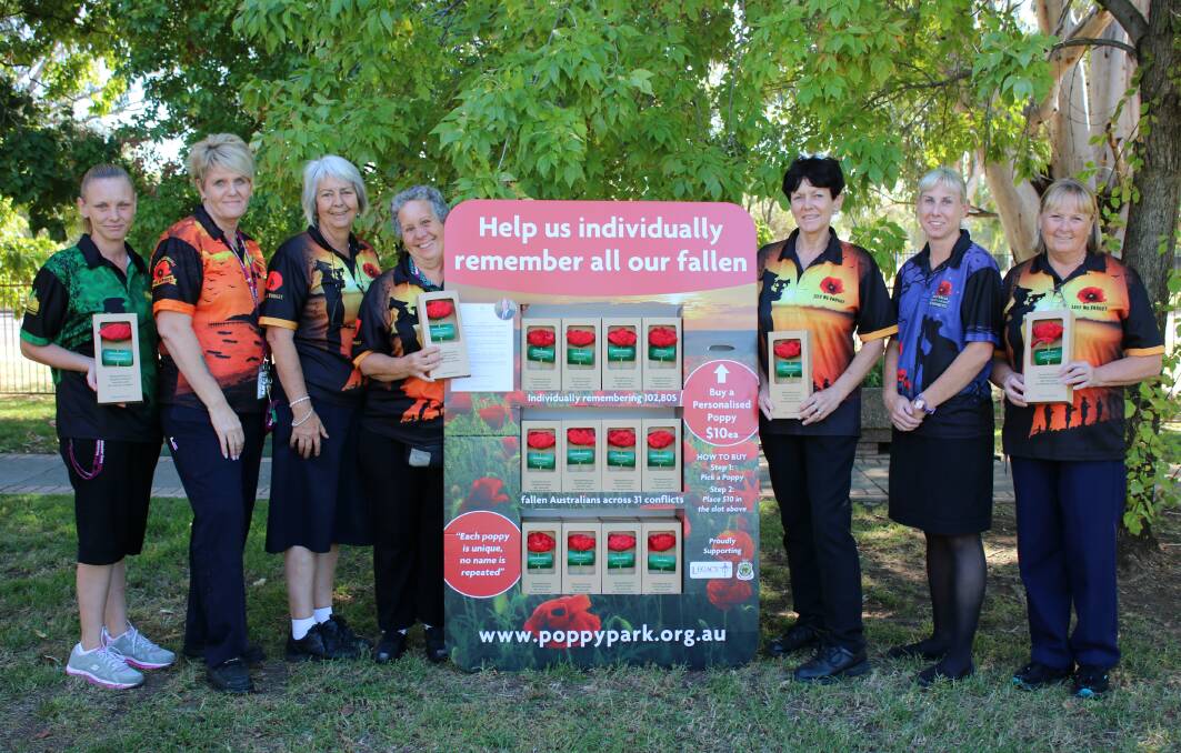 REMEMBER THE FALLEN: Michelle Silver, Tess Cheetham, Wendy Hatch, Sue Smith, Pam Sleath, Casey Hatch and Sue Fulwood with a stand of personalised poppies which are available for $10 each from Mackellar Care Services.