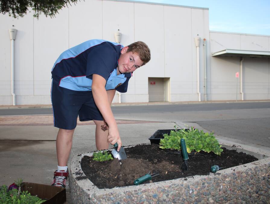 FRESH IDEAS: Gunnedah Youth Council member, Thomas Bush, plants some flowers ahead of the pop-up dessert bar event in October.