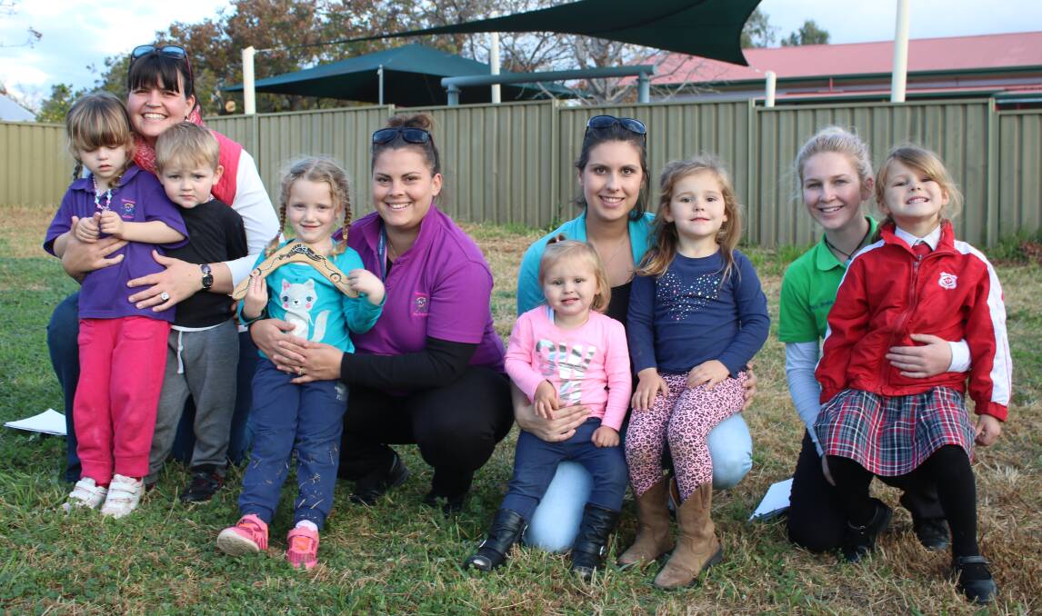 Gunnedah Preschool board members, Michelle Grace (left) and Liz Morris (second from right) with their children, and childcare educators Sam Redfern and Braie Devine on the site where the playground will be constructed.