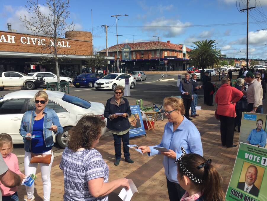 Warm welcome: Voters navigate their way through the candidate crush at the Gunnedah Town Hall polling centre where nominees were rallying last-minute votes.