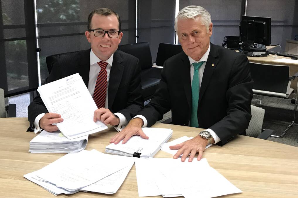 Daylight pledge: Northern Tablelands MP Adam Marshall, left, and Tweed MP Geoff Provest with the more than 6,000-signature strong petition for a one-month reduction in daylight saving. Mr Provest will soon introduce the bill into the legislative assembly.