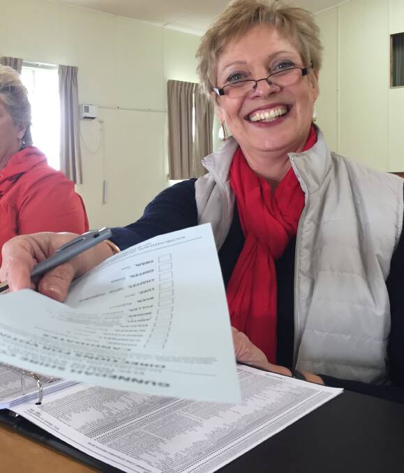 Friendly face: Curlewis polling centre manager Helen Johnston hands out a ballot paper during Saturday's Gunnedah Shire Council election.
