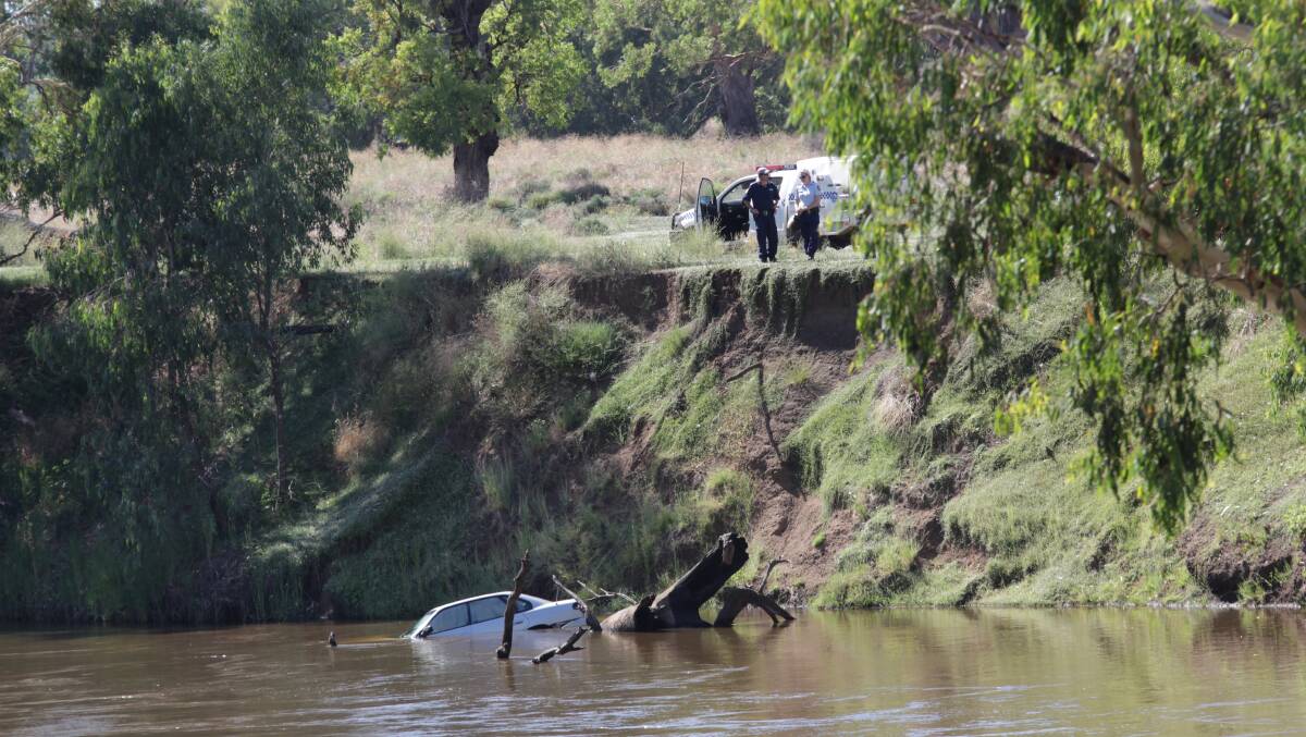 Police at the scene where the car was found dumped in the Namoi River on Monday morning.