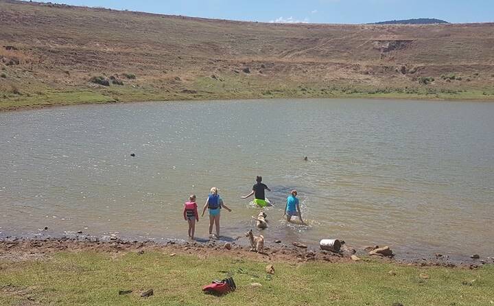 Some relief: The Scott family cool off at their property dam on Friday after weathering 42-degree temperatures without electricity for nearly 24 hours. A fallen power pole on Wandobah Road was to blame for the lengthy outage.