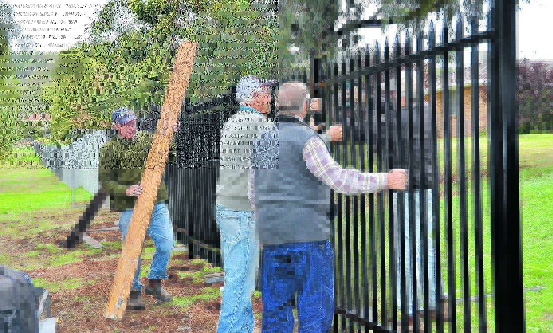 IN ACTION: Men at work on the the Village Homes fence.