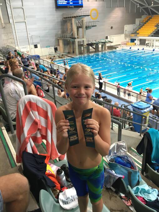 Top job: Nash Boal displays his two finalist ribbons from the Speedo Sprints held in Sydney recently. The pocket rocket, 7, made the final of the freestyle and butterfly.
