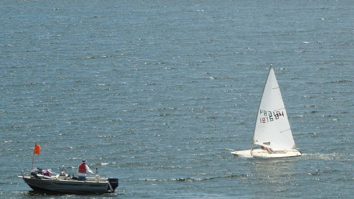 Ultimate winner of the Vice-Commodore’s Plate, Robert Cull of Lake Keepit, sailing his laser class dinghy, about to cross the finish line under the watchful gaze of race officials. 