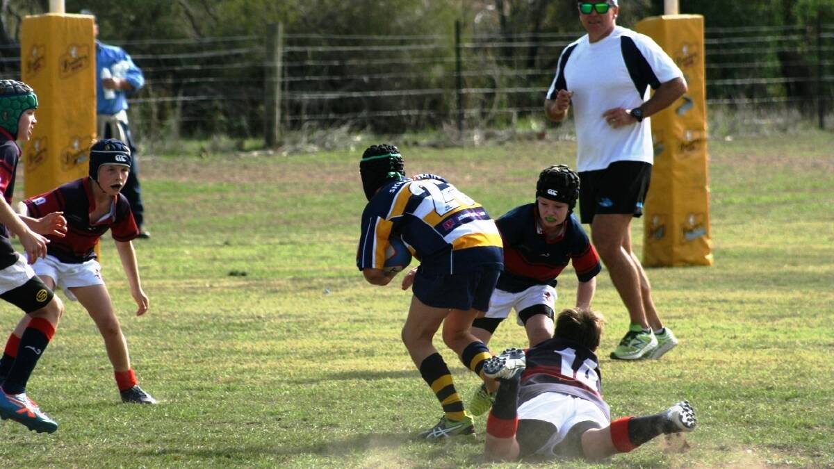 Gunnedah under 12s players Sam Sawyer and Rowand Kelly try to bring their opposition player to ground.