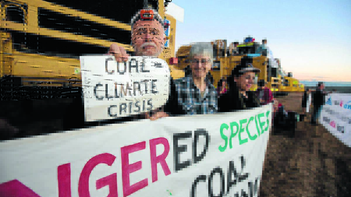 Protestors chained themselves to large machinery and held banners after a protest at the Maules Creek coal mine site intensified yesterday. 