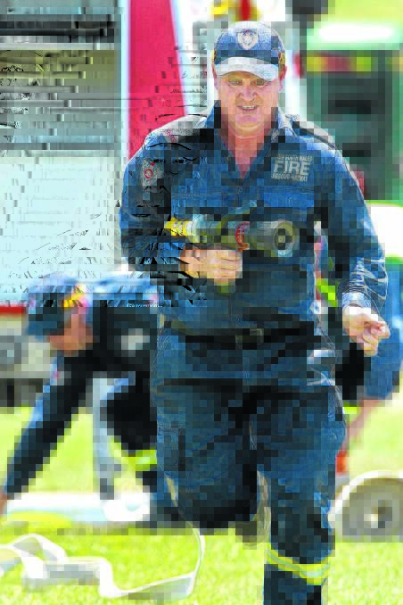 Retained firefighter Mark Sawyer makes a run for it in a hose event. Photo: Fire and Rescue NSW Media.