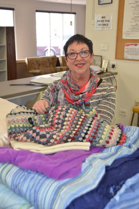 Gunnedah Salvation Army store volunteer Jenny Connor with a pile of blankets ready for the winter months. 
