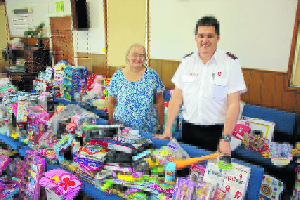 Helper Janette Trindall and Gunnedah Salvation Army captain Richard Day with some of the items which will spread joy in the community this Christmas.