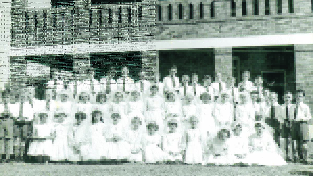 ST Xavier’s second class of 1961. Communion group: Back from left, Ray Gaynor, Richard Gallen, Paul Mooney, Tim Lawrence, Stephen Donaghue, Ray Darcey, Peter Maxwell, James McCormick, Shane Hope, Joe Hunt, Andrew Costigan, Michael Jansson, Patrick Campbell, Mark Donnelly and Brendan McGee. Middle: Tim Poynting, Robert Thibault, Michael Beeson, John Grace, Marie Pollock, Cheryl Britten, Angelina Bianchino, Lyn Scott, Sharyn Burke, Sue Welsh, Janet Freeman, Joan Hartley, Sue Dillon, Kim Clift, Anne Richardson, Peter Koch, Graham Novelly, David Platt, David Matthews and Phillip Hinschelwood. Front: Helen Maroney, Janice Rootes, Helen Mansour, Marcia Bettridge, Yvonne Dillon, Karen Beer, Alice Rugers, Christine Maley, Helen Beard, Therese Donnelly, Agnes Bailey and Jane Bailey.