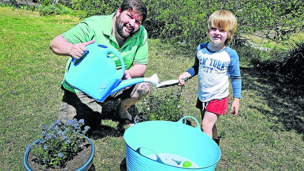 EVERY DROP COUNTS: Tamworth resident Simon Fearby teaches his four-year-old son, Gabriel, about the importance of conserving water. Photo: Geoff O Neill 061014GOC01