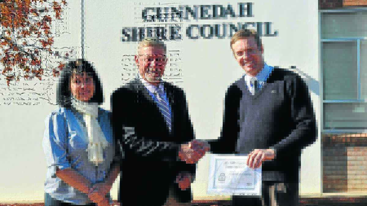 DEBRA Hilton and Mayor Owen Hasler are congratulated by NRMA Insurance Gunnedah representative Donald Whiteman on receiving a community grant for council’s Gunny Get Your Home Secure Kit project.