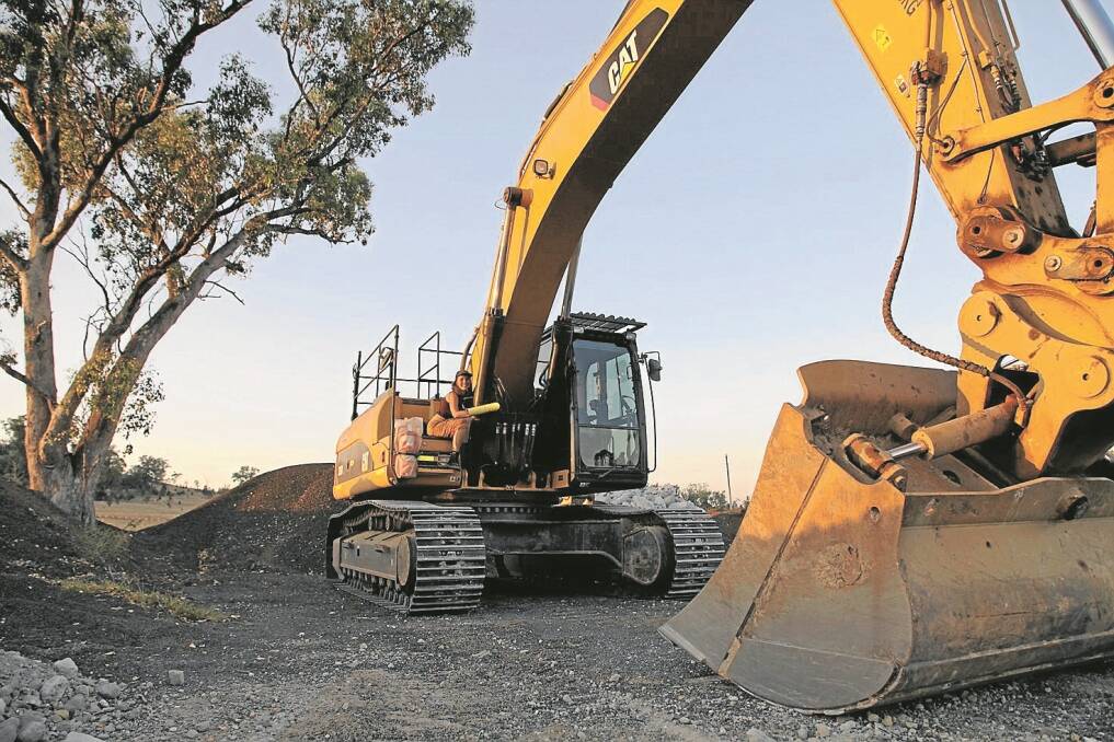 Mikaila Hanman Siegersma locked onto an excavator at the construction site off Therribri Road on Tuesday. Her actions topped a day of tree clearing along the Namoi River where Whitehaven Coal and Idemitsu are undertaking construction work for the coal rail line.
