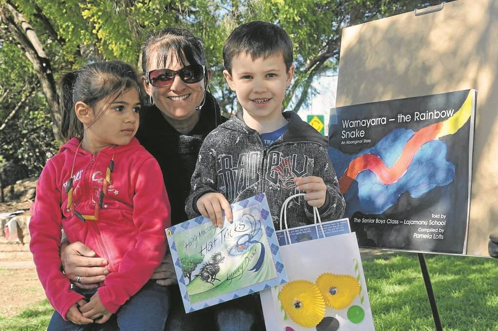CHILDREN flocked to listen to Storytime at the family fun day. Pictured are storyteller Michelle Horvat, with Mikaela Harris (4) and Lincoln James (6), who decorated their own carry bags and received a gift of a book. 