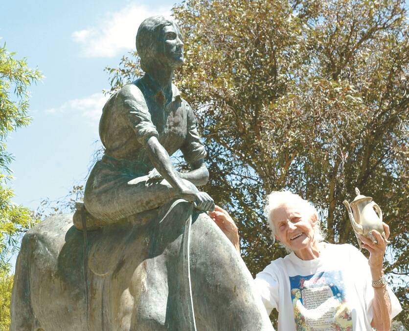 MIKIE Maas in January 2008 when she re-visited the scene of one of her most rewarding projects – the Dorothea Mackellar Memorial statue, erected in ANZAC Park in 1983. Mikie is wearing her Dorothea shirt printed with Dorothea’s Gunnedah poem, Dawn, and holding the silver engraved coffee pot she received in recognition of her fund-raising efforts.