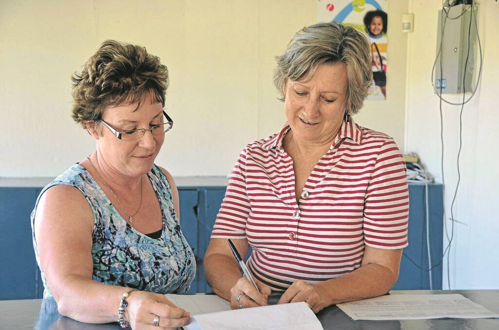 ROBYN Traynor, left, explains the petition to Sandie Walker as she signs to ban synthetic cannabis as a legal substance.