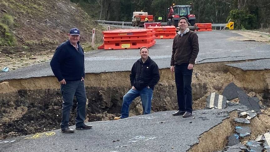 Upper Hunter mayor Maurice Collison, general manager Greg McDonald and Upper Hunter MP David Layzell stand in a deep crack on the failed Merriwa to Willow Tree Road. Picture supplied, from file