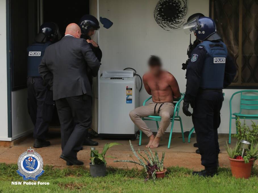 Under arrest: Western Region OSG police and strike force detectives swoop on two houses in Wee Waa on Wednesday. Photo: NSW Police Force
