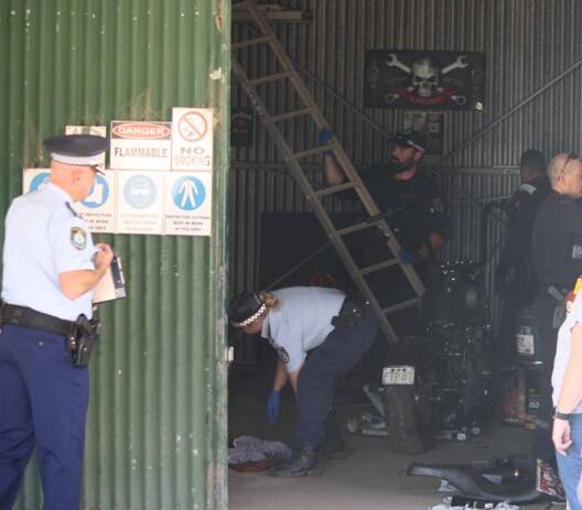 Show of force: Oxley police and Strike Force Raptor officers search a property during a series of raids on Friday and Saturday. Photo: Oxley Police 