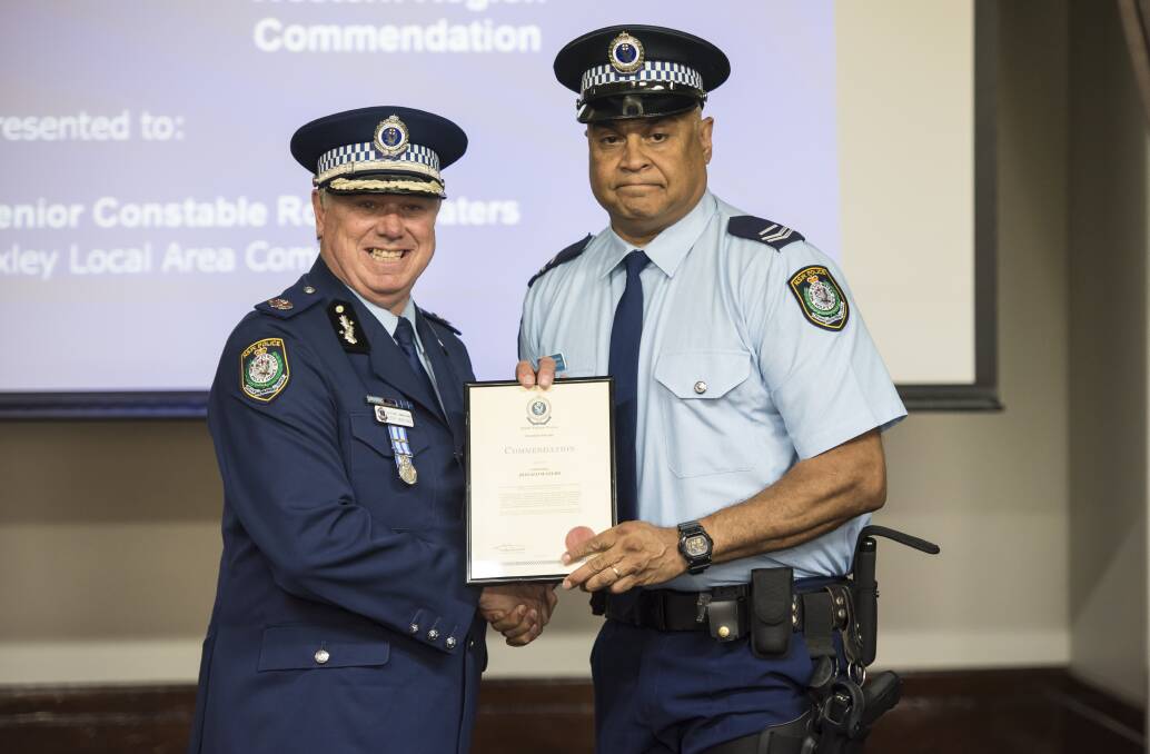 Above and beyond: Senior Constable Ron Waters is presented with his award by Assistant Commissioner Geoff McKechnie. Photo: Peter Hardin