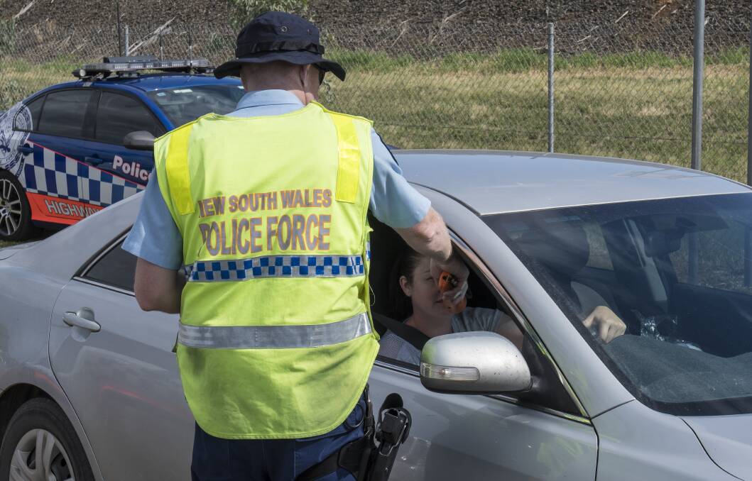High visibility blitz: Oxley highway patrol officers breath test drivers on the side of the New England Highway in Tamworth. Extra officers will be on the roads to police the festive season. Photo: Peter Hardin