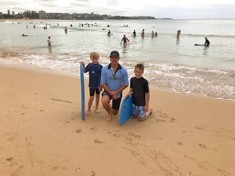 Mullaley youth Charlie Rose and Goolhi youth Will D'Hudson with a Manly lifeguard. Photo: Andrew Prentice