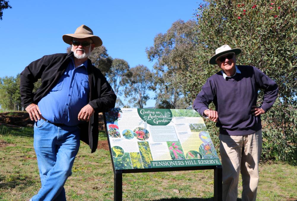Pat Mayoh and Terry Curran with one of the newly installed signs depicting images and details about the flora planted throughout the reserve. 