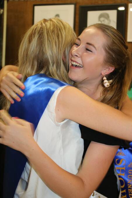 2018 Gunnedah Showgirl Haylee Murrell hugs 2017 Gunnedah Showgirl Sophie Clift when her name is announced at the opening of the Art and Photography Pavilion.