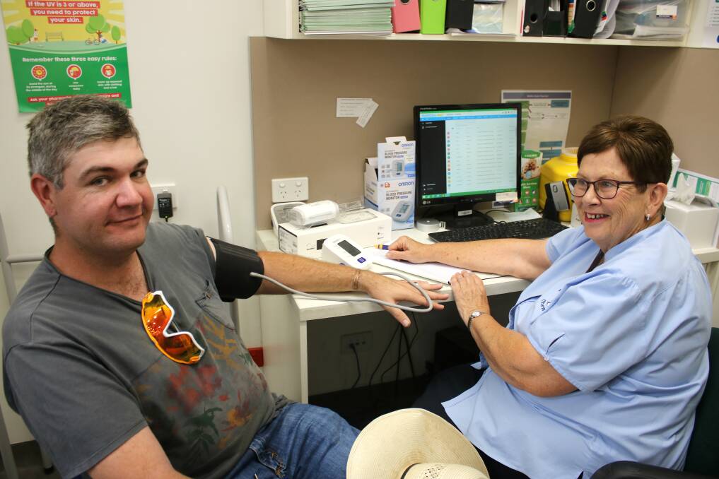 Nurse Chris Mirow (right) takes Nathan Barnes' blood pressure at Karen Carter Chemist on Tuesday.