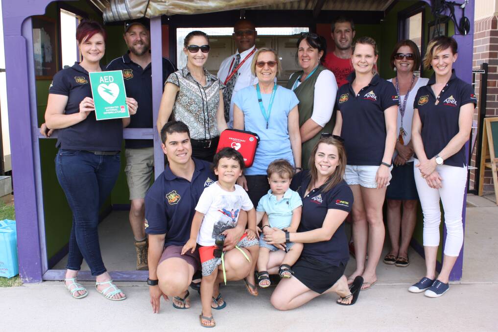 Apex gives a defibrillator to GS Kidd Memorial School in 2015. Back (from left) Anthony Dein, Paul Williams, Benji Trieger and Karen Hobson. Middle: Amanda Bennetts, Sharne Turpin, Kim Gibson, Vicki Urquhart, Allyson Hoban and Rebecca Barlow. Front: Ian, Reuben, Dustin and Hollie Crawford.