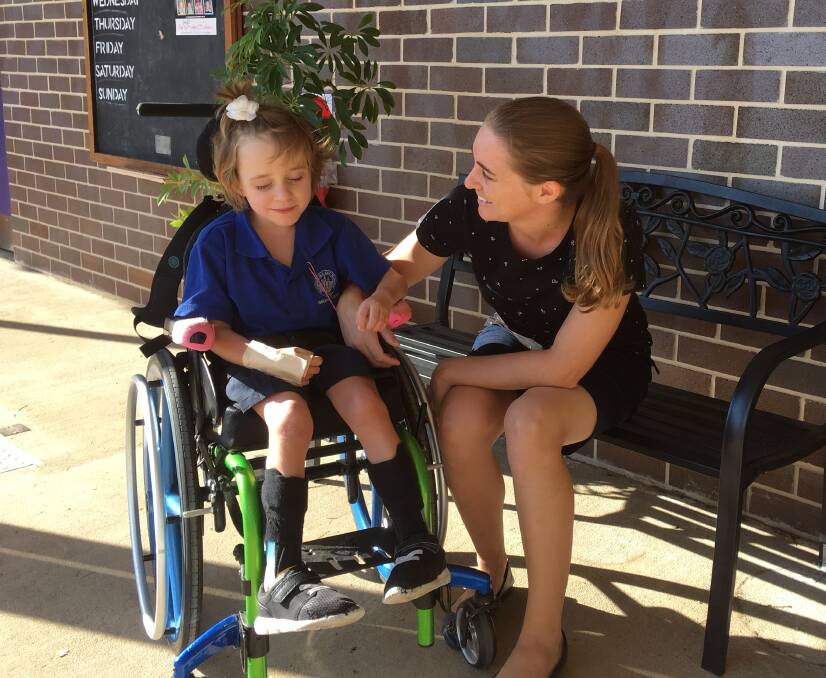 HANDS UP FOR LUCY: Lucy Enks and her mother Amy Elton at Gs Kidd Memorial School. Lucy needs a wheelchair to get around and a modified vehicle would be a great help. Photo: Supplied 