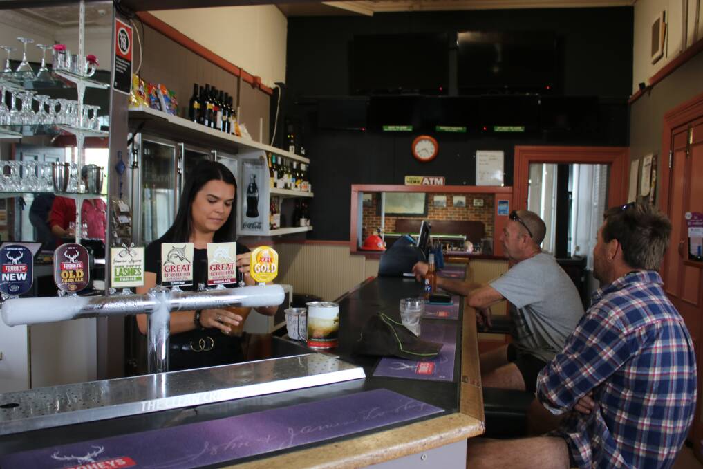 Courtney serving in the Curlewis pub on the first day it reopened in March under the ownership of Erin Van Beeck and Matt White. She and her friend Rachel are backpackers from Canada.