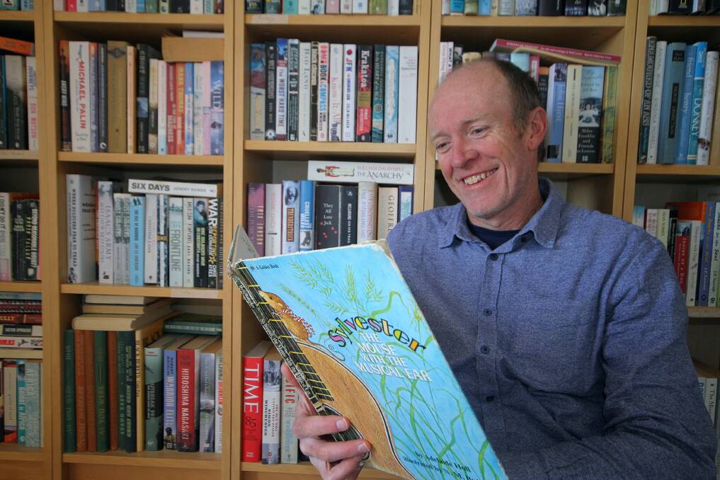Ex-Gunnedah author James Knight is writing his first children's book. He is pictured here with his "all-time favourite" book, Sylvester the Musical Mouse, gifted to him by his mother in his childhood. Photo: supplied