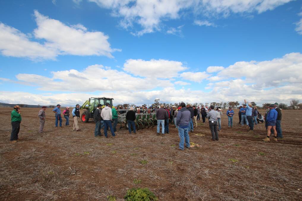 Farmers gather around the weed chipper. Photo: Bill Manning
