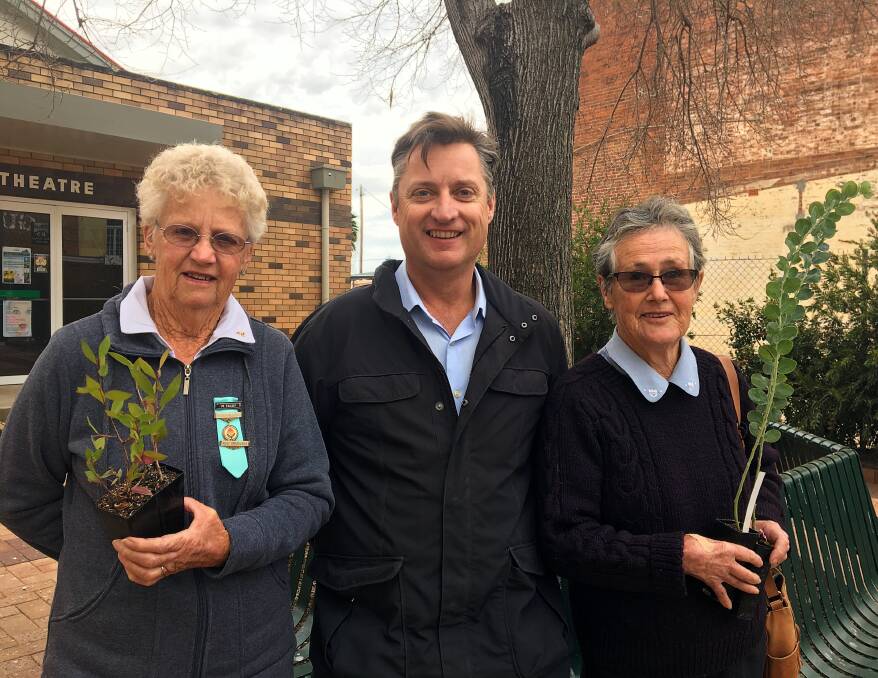 Gunnedah shire mayor Jamie Chaffey (centre) with two local seniors collecting free native trees in Local Government Week last year. Photo: supplied