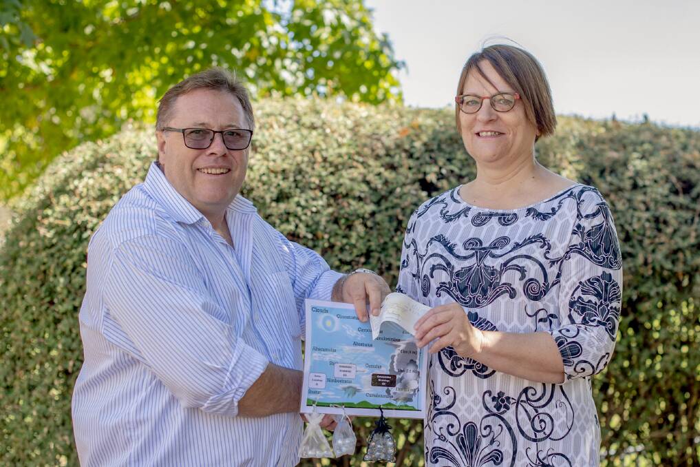 Namoi Partner Schools' Ken White receives the drought funds from Hanna Lichti. The funds will be used to benefit local students. Photo: Alyssa Barwick