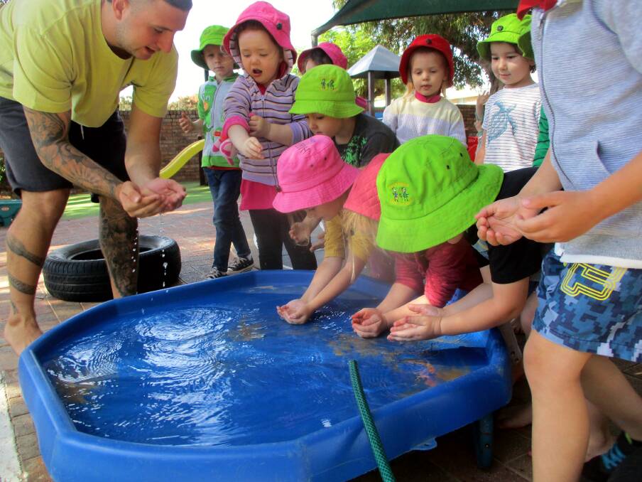 Gamilaroi man James Hogbin, aka Frog, shows pre-schoolers at Mary Ranken how to drink water from a river. Photos: Supplied