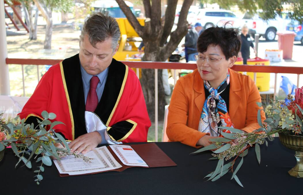 Gunnedah shire mayor Jamie Chaffey and Yinzhou government delegate Lyu Hongqin sign a sister city agreement in 2017.