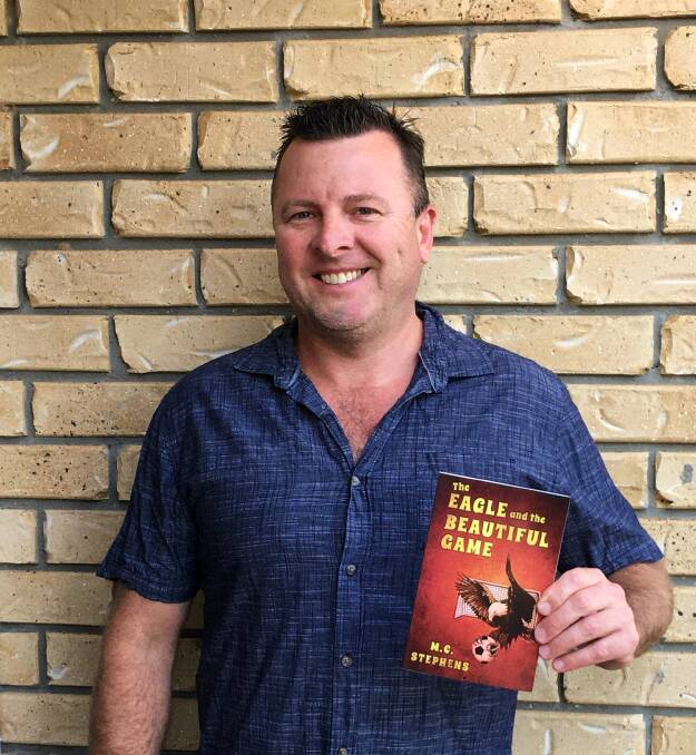 Matt Stephens with a copy of his first book, The Eagle and the Beautiful Game. Photo: supplied