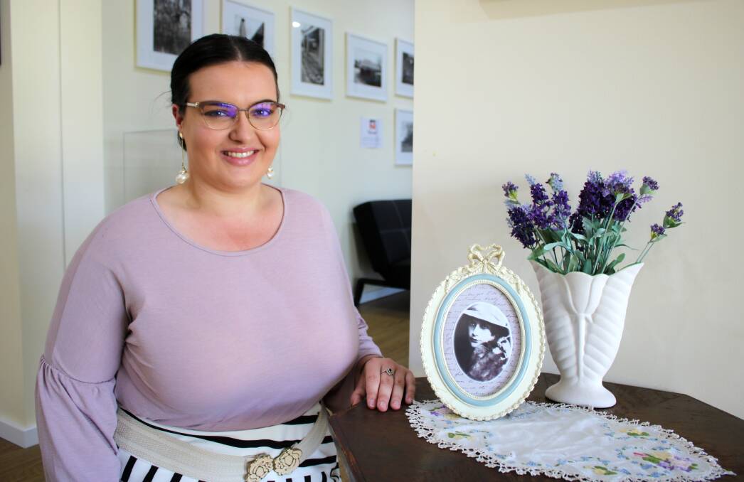 Poetry awards officer Brittany Riley with a portrait of the late Dorothea Mackellar at The Mackellar Centre.