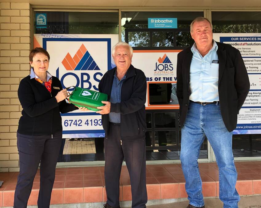 Jobs Australia's Tracey Reid and Gunnedah RDA president Max Small with the defibrillator sourced through Cooridoon Health Services' Bill Ashford, right. Photo: supplied