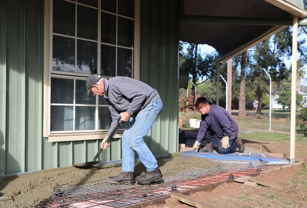 Gunnedah Rural Museum members Neville O'Gorman and Kerry Bee work on a foothpath extension around the side of the main building.