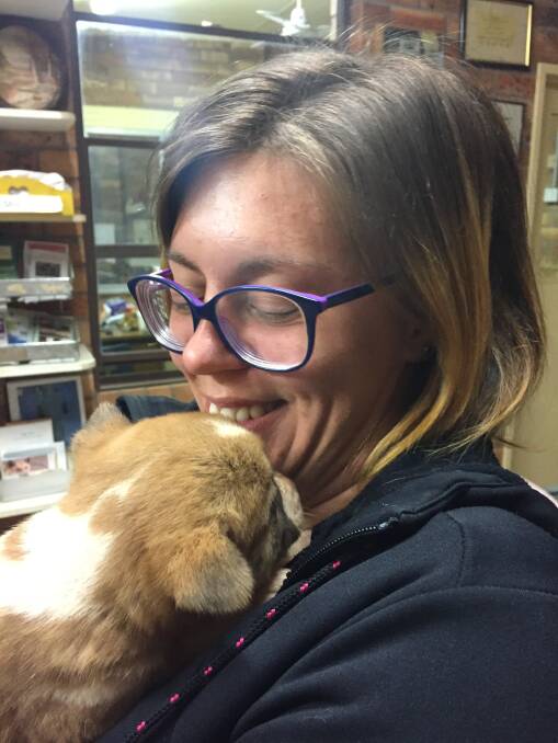 French backpacker Julie Ratte cuddles up to a purebred Dingo pup at the park.