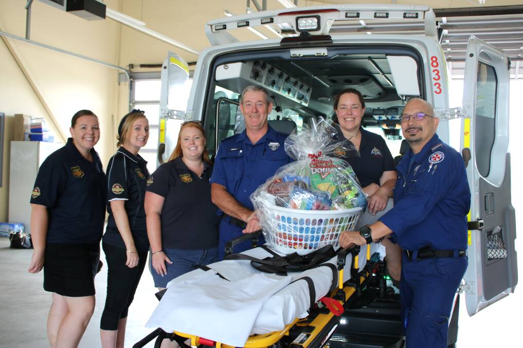 GIFT: Apex members Aylish Flannery, Ashlee Sheedy, Heather Lidwinski and Donna Austin deliver a Christmas food hamper to paramedics Gary Revell and Luis R de Luzuriaga at the Gunnedah ambulance station.
