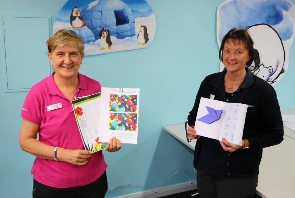 Gunnedah Shire Library's Christiane Birkett and Robyn Draper with some of the activities used in the Brain Training program.